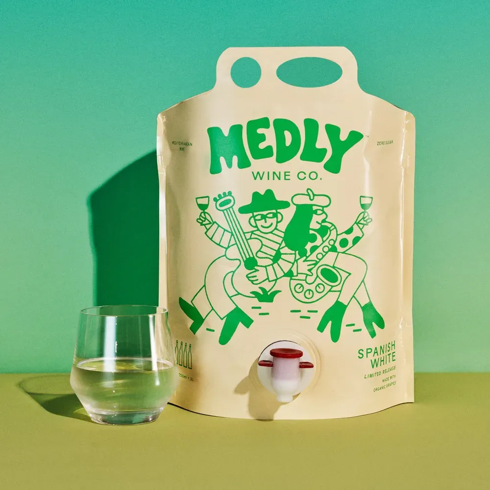 A Medly Spanish White wine pouch beside a glass of white wine