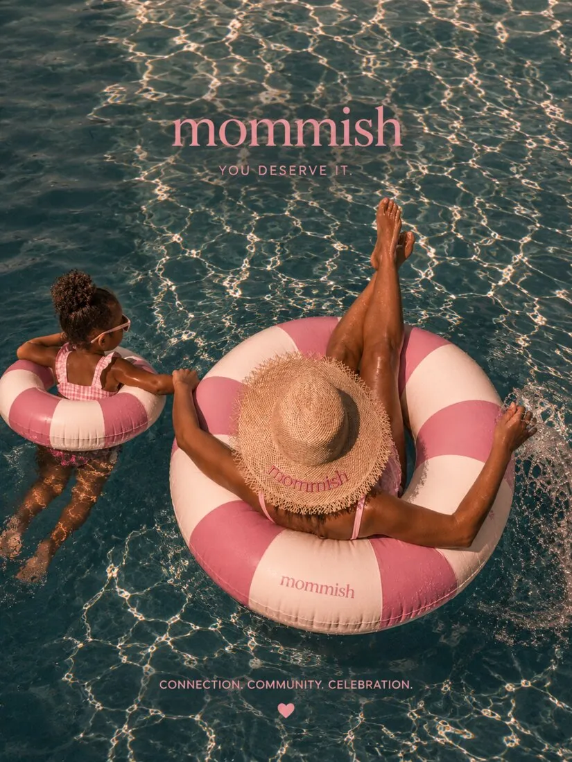 A mom in a straw hat that reads mommish floats in a pink-striped ring beside her daughter in a matching one